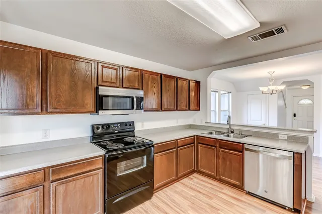 a kitchen with stainless steel appliances granite countertop a sink stove cabinets and microwave