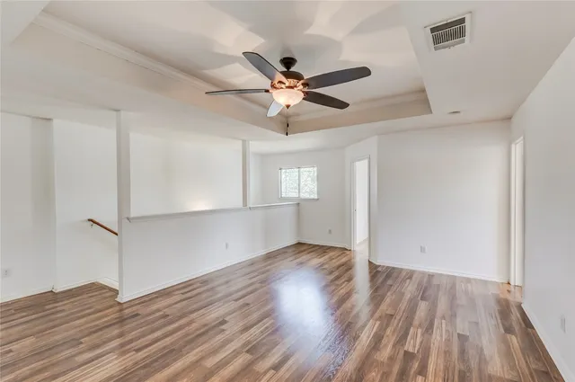 an empty room with wooden floor a ceiling fan and closet