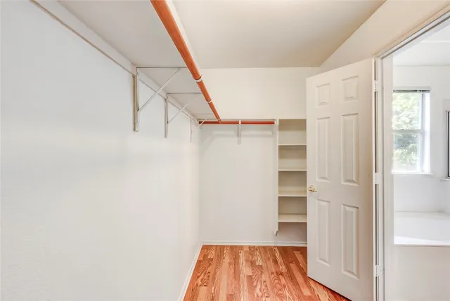 a view of walk in closet with empty racks