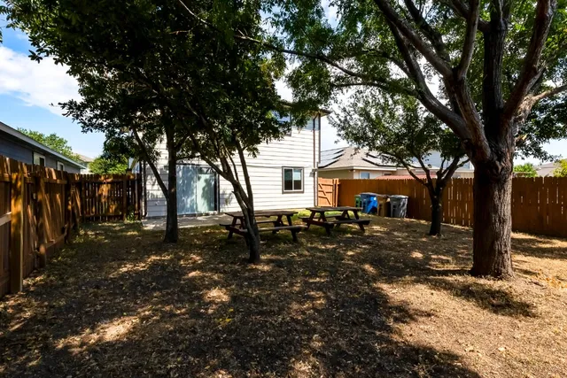 a backyard of a house with tub and trees