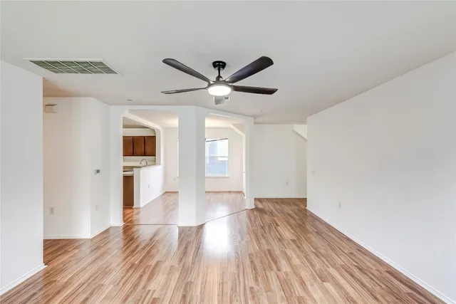 a view of empty room with wooden floor