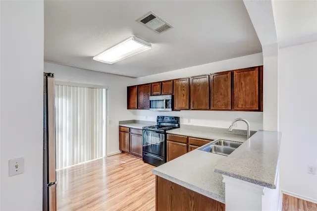 a kitchen with stainless steel appliances granite countertop a sink stove and refrigerator