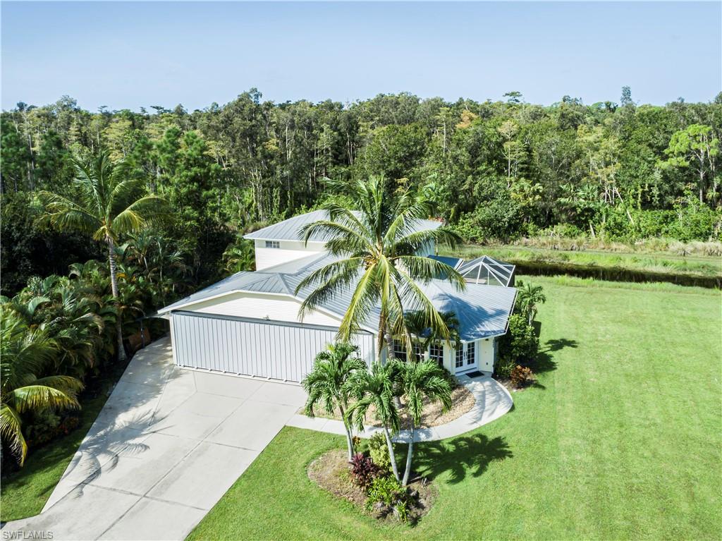 a view of a house with a yard and potted plants