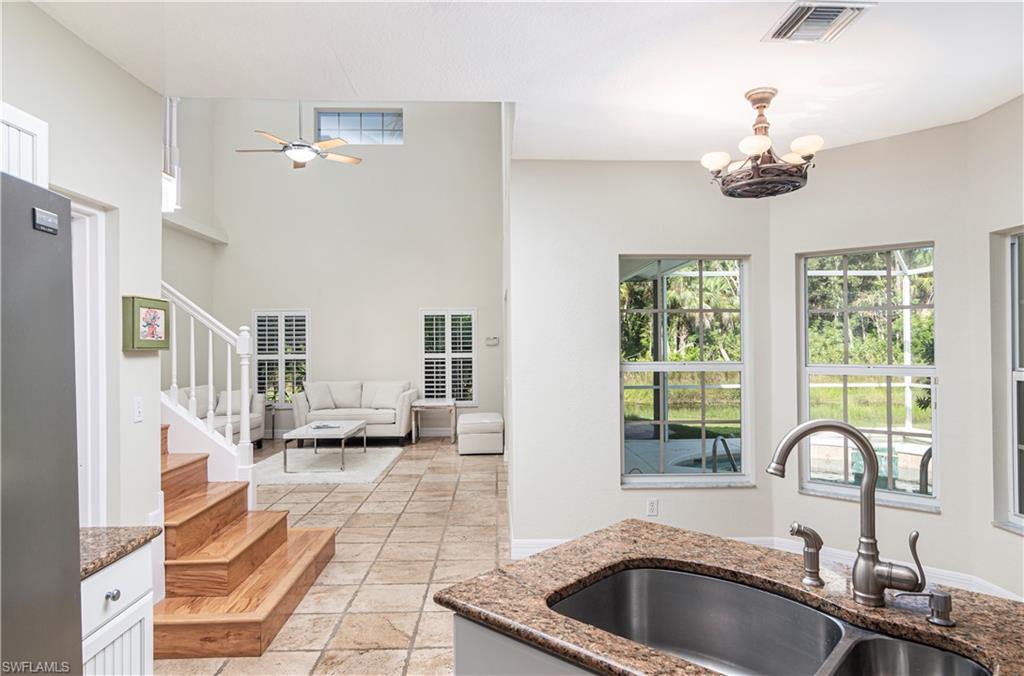 4049 Skyway Drive Naples, FL 34112 - Photo 11 of 31 a kitchen with stainless steel appliances granite countertop a sink dishwasher and white cabinets next to a large window