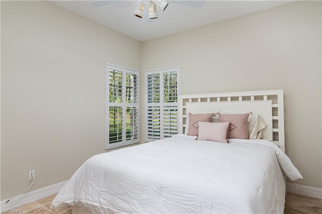 4049 Skyway Drive Naples, FL 34112 - Photo 14 of 31 a bedroom with a large bed and a large window