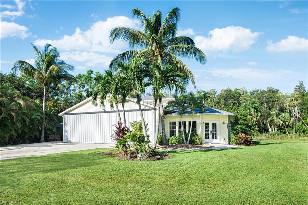 4049 Skyway Drive Naples, FL 34112 - Photo 2 of 31 a front view of a house with a garden