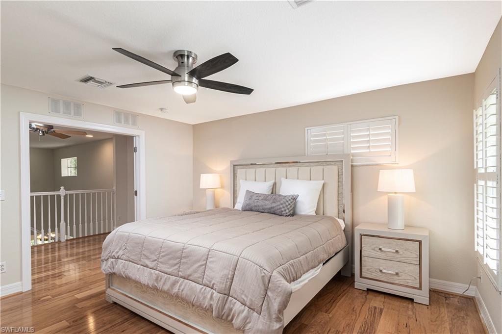 4049 Skyway Drive Naples, FL 34112 - Photo 21 of 31 a bedroom with a large bed and a chandelier