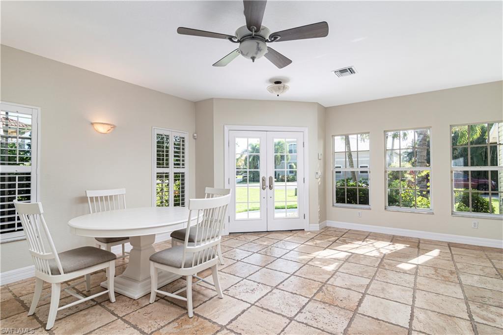 4049 Skyway Drive Naples, FL 34112 - Photo 7 of 31 a living room with a large window a dining table and chairs