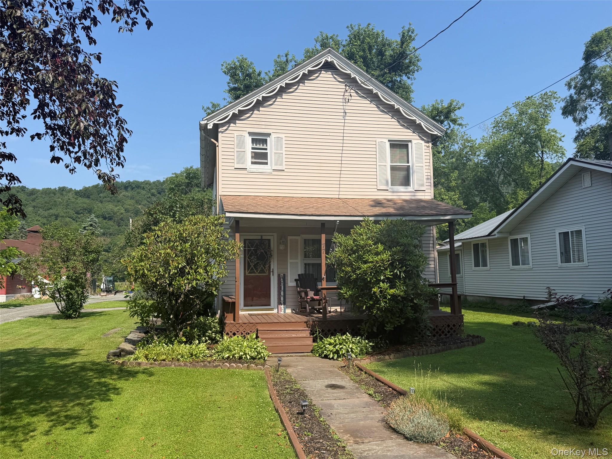 77 Rockland Road Roscoe, NY 12776 - Photo 1 of 20 Two-story residence featuring light-colored siding, a covered front porch, and decorative gable trim