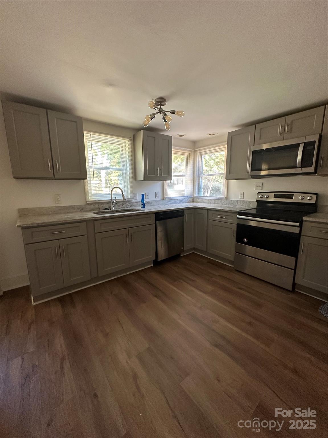 1215 Summerville Road, Unit 112 Charlotte, NC 28214 - Photo 17 of 20 a large kitchen with wooden floors and stainless steel appliances