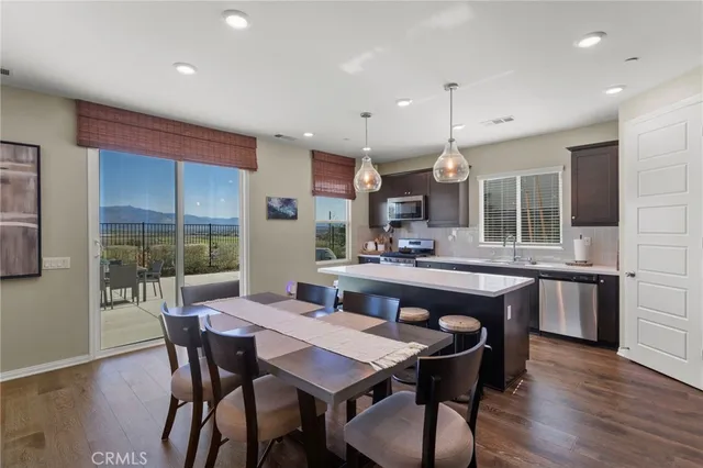 a dining area with a table chairs and a kitchen view
