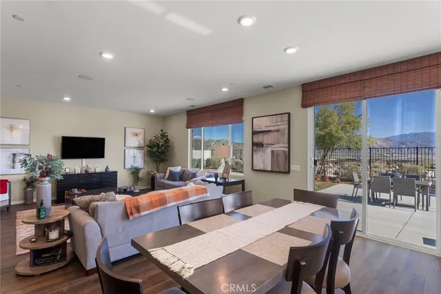 a living room with furniture a flat screen tv and a large window