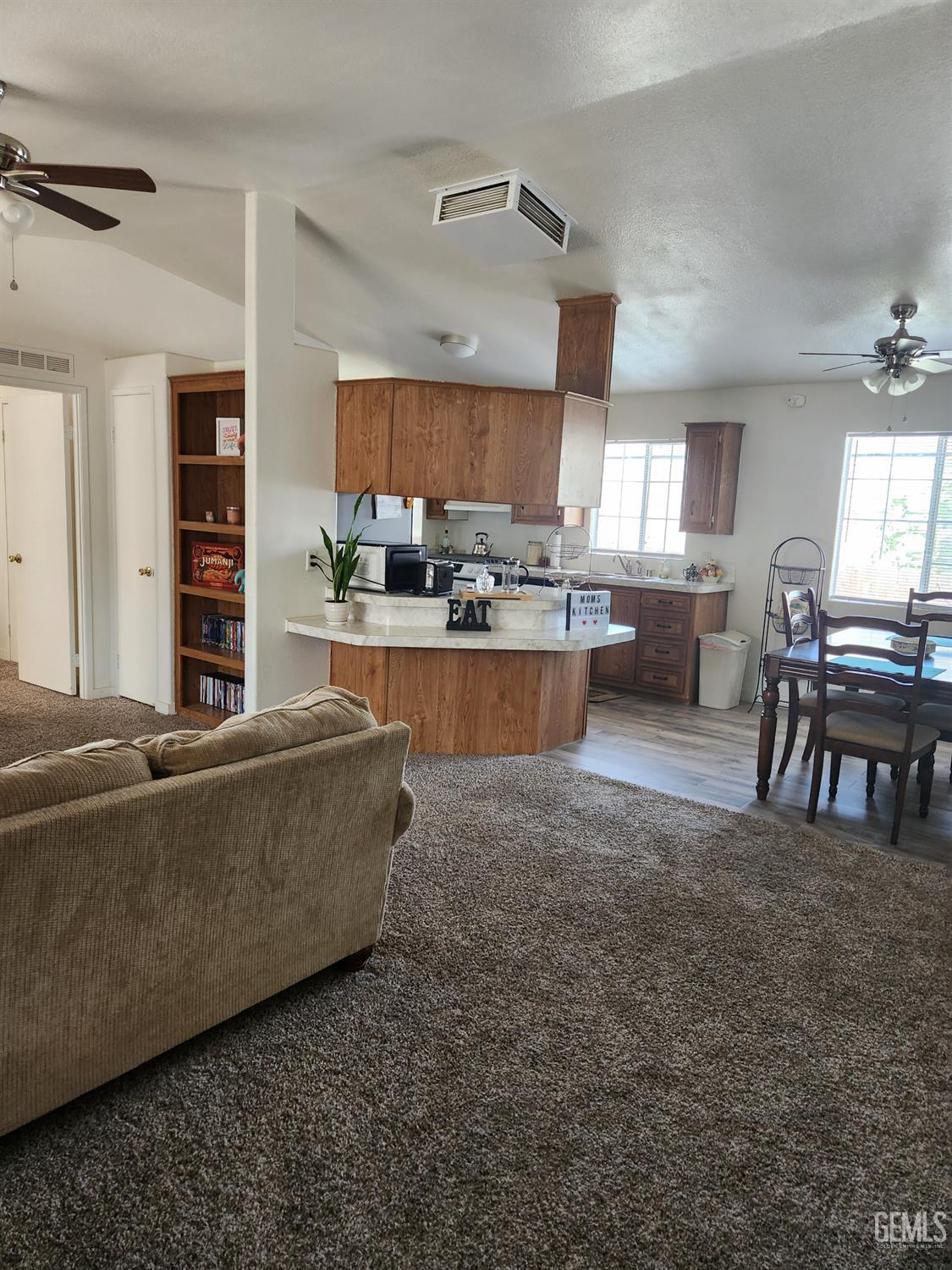 Undisclosed Address Bakersfield, CA 93314 - Photo 6 of 28 a living room with furniture and a dining table with kitchen appliances