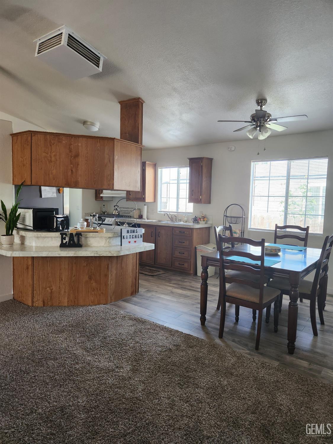 Undisclosed Address Bakersfield, CA 93314 - Photo 8 of 28 a kitchen with a table chairs a sink dishwasher window and cabinets