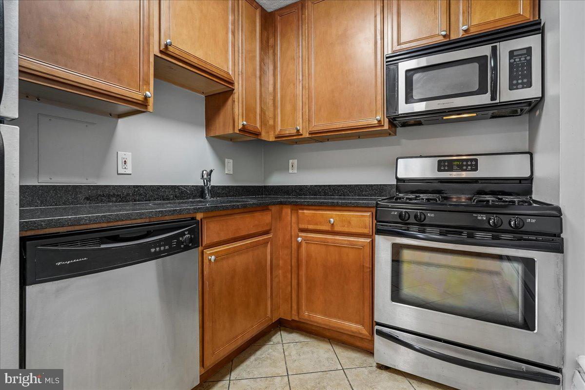 1245 4th Street Southwest, Unit E409 Washington, DC 20024 - Photo 10 of 21 a kitchen with stainless steel appliances granite countertop a stove microwave and sink