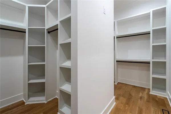 a room with walk in closet with wooden floor