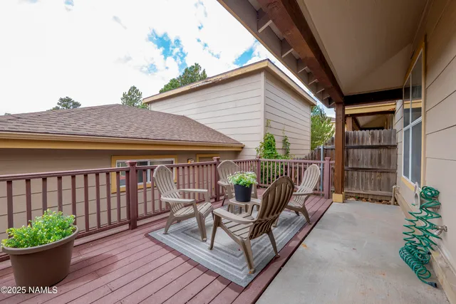 a view of a house with wooden deck and furniture