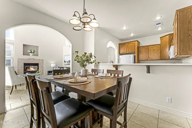 a view of a dining room with furniture a chandelier and wooden floor