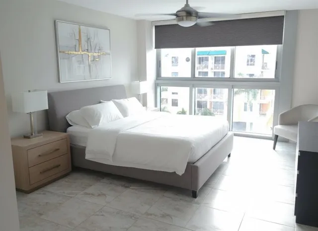 a bedroom with a bed a table and painting on the wall