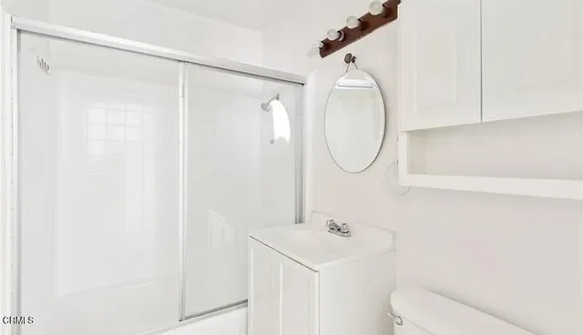 a bathroom with a sink vanity mirror and toilet