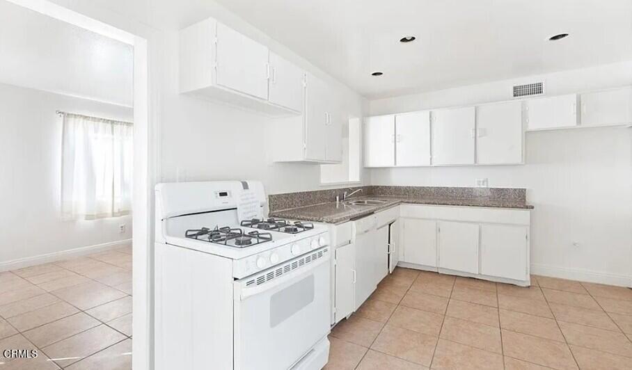 356 East Kettering Street Lancaster, CA 93535 - Photo 2 of 14 a white kitchen with stove top oven and cabinets