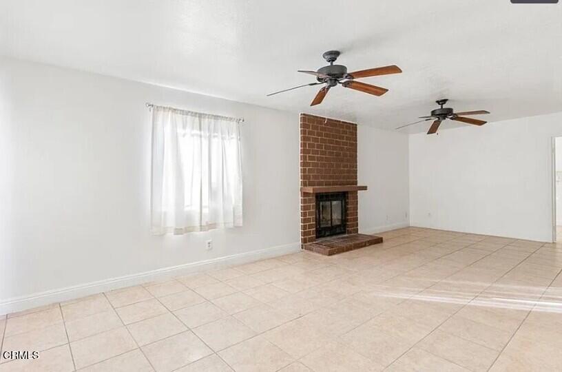 356 East Kettering Street Lancaster, CA 93535 - Photo 6 of 14 a view of an empty room with a fireplace and a window