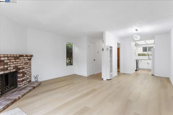 a view of a big room with wooden floor and a window