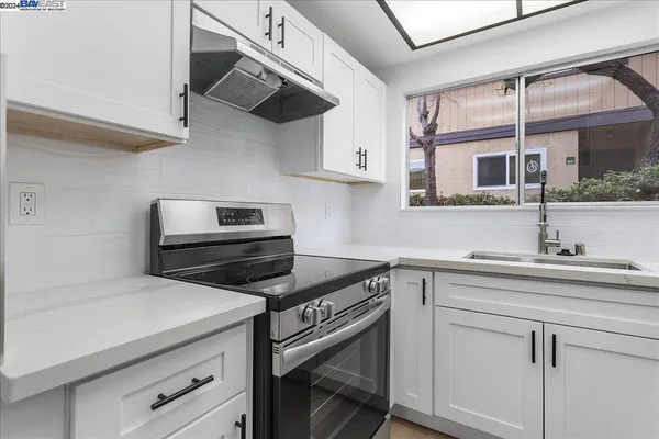 a kitchen with white cabinets and a sink