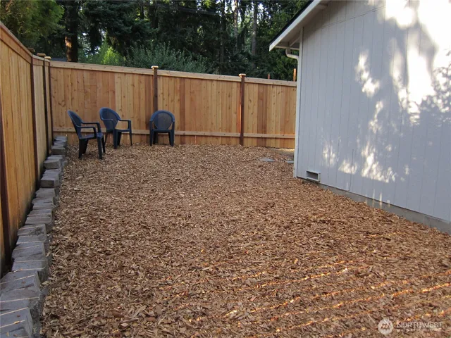 a backyard of a house with table and chairs