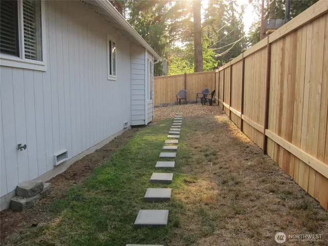 a view of a yard with wooden fence