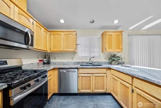 a kitchen with stainless steel appliances granite countertop a sink and stove top oven
