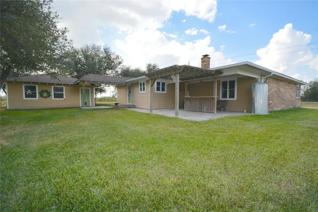 a view of a house with big yard and large trees
