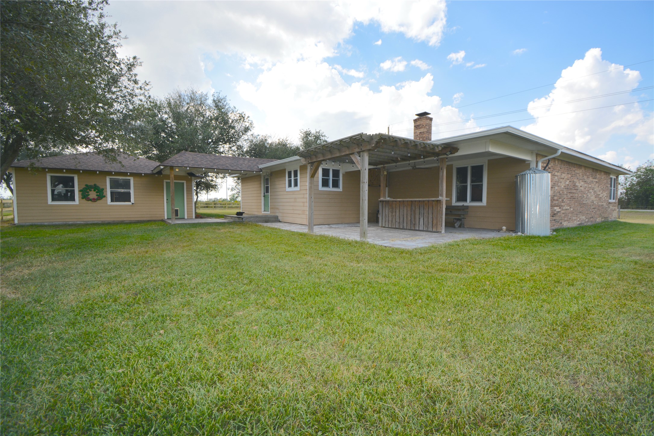 a view of a house with big yard and large trees