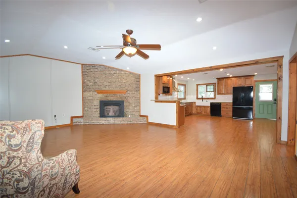 a view of a livingroom with furniture a ceiling fan and wooden floor