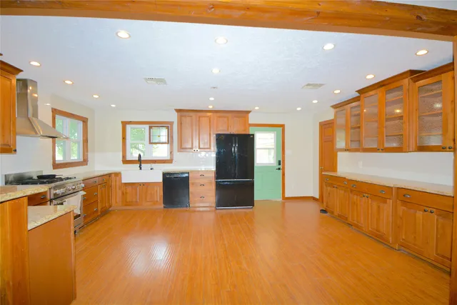 a large kitchen with stainless steel appliances granite countertop a large counter top a stove and a refrigerator