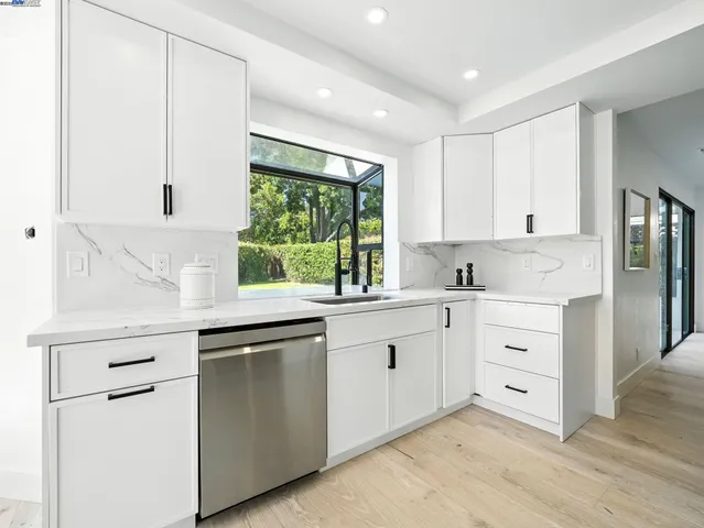 a kitchen with granite countertop white cabinets and white appliances