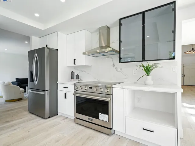 a kitchen with stainless steel appliances a stove a refrigerator and cabinets