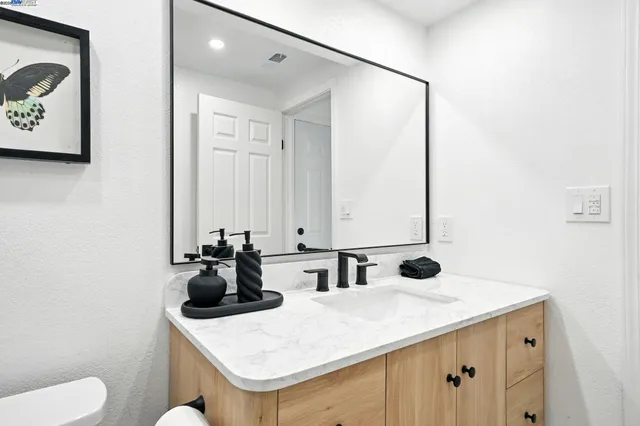 a bathroom with a sink and mirror with toilet