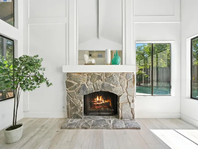 a living room with a fireplace and a potted plant