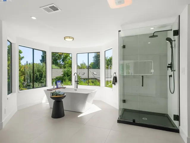 a living room with a large window and a glass door shower