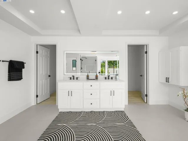 a spacious bathroom with a shower a mirror and a sink