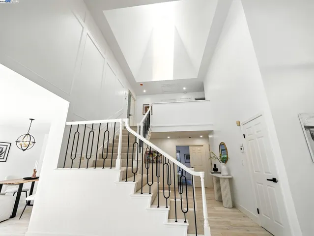 a view of staircase with railing and white walls