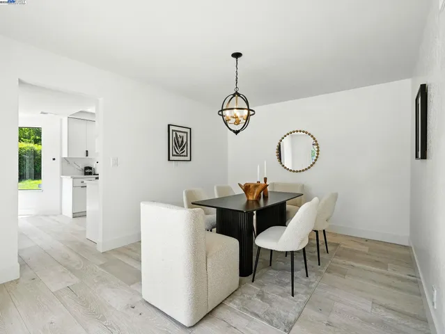 a living room with couches a dining table and chairs with wooden floor