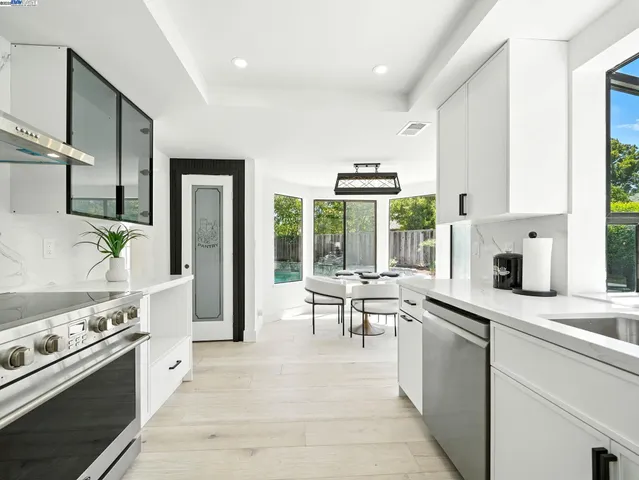 a kitchen with stainless steel appliances granite countertop a stove a sink and a refrigerator