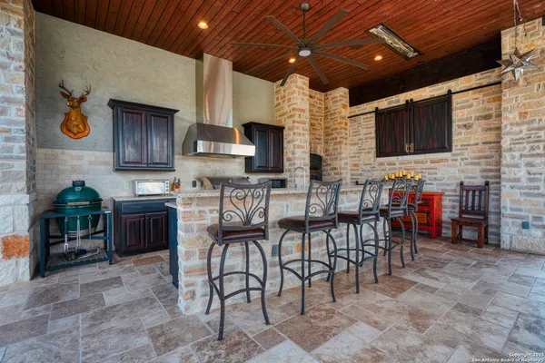a kitchen with stainless steel appliances kitchen island granite countertop a table chairs sink and cabinets