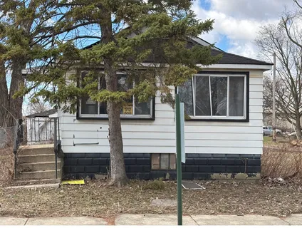 a view of a house with a yard tree and wooden fence