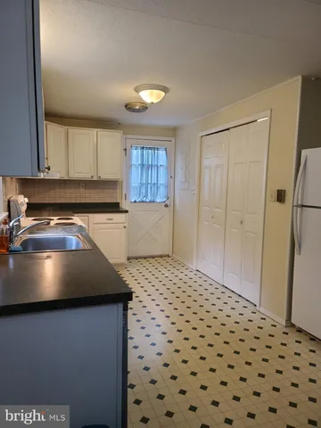 a kitchen with a sink a stove and a refrigerator