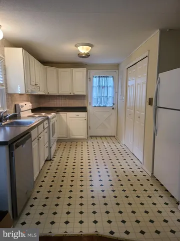a kitchen with a sink a refrigerator and cabinets