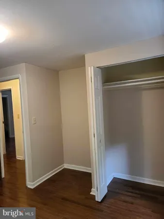 an empty room with wooden floor and closet