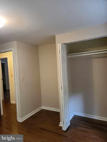 an empty room with wooden floor and closet
